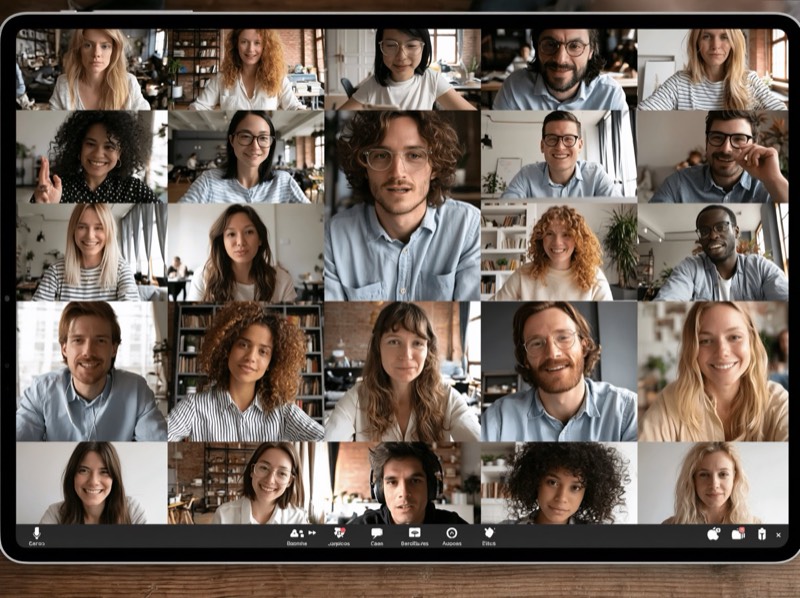 Tablet mit einer Videokonferenz in Kachelansicht, rund 25 Teilnehmende.